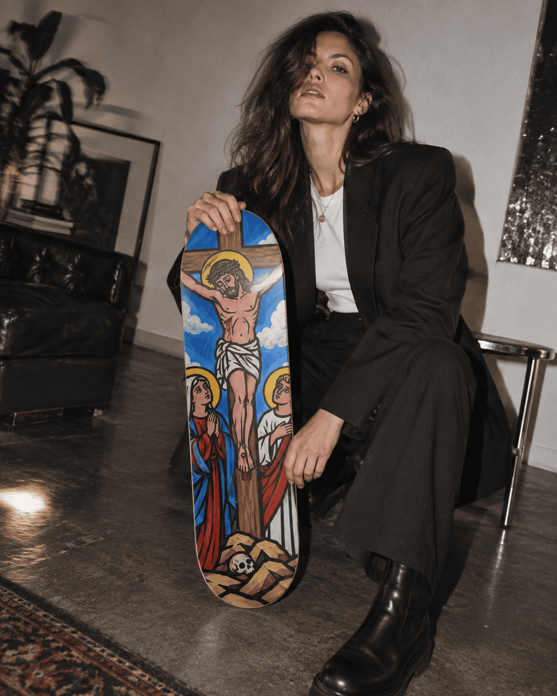 The Crucifixion Biblical Series skateboard wall art held by a model in a black tailored suit