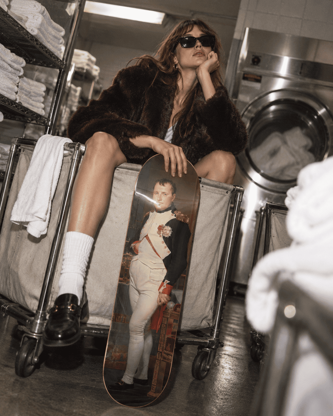 David Napoleon in His Study skateboard deck leaning against a laundry cart in a real overnight industrial laundry