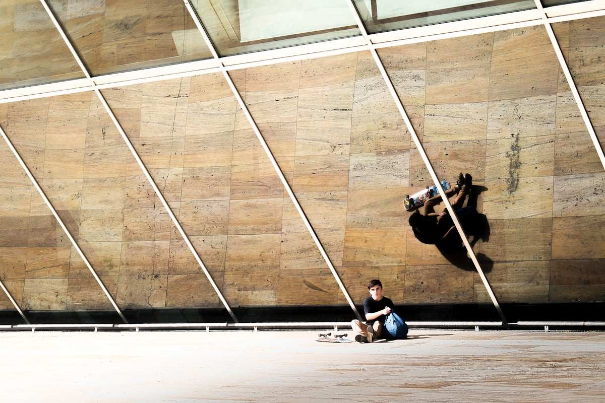 a person sitting on the ground with a skateboard