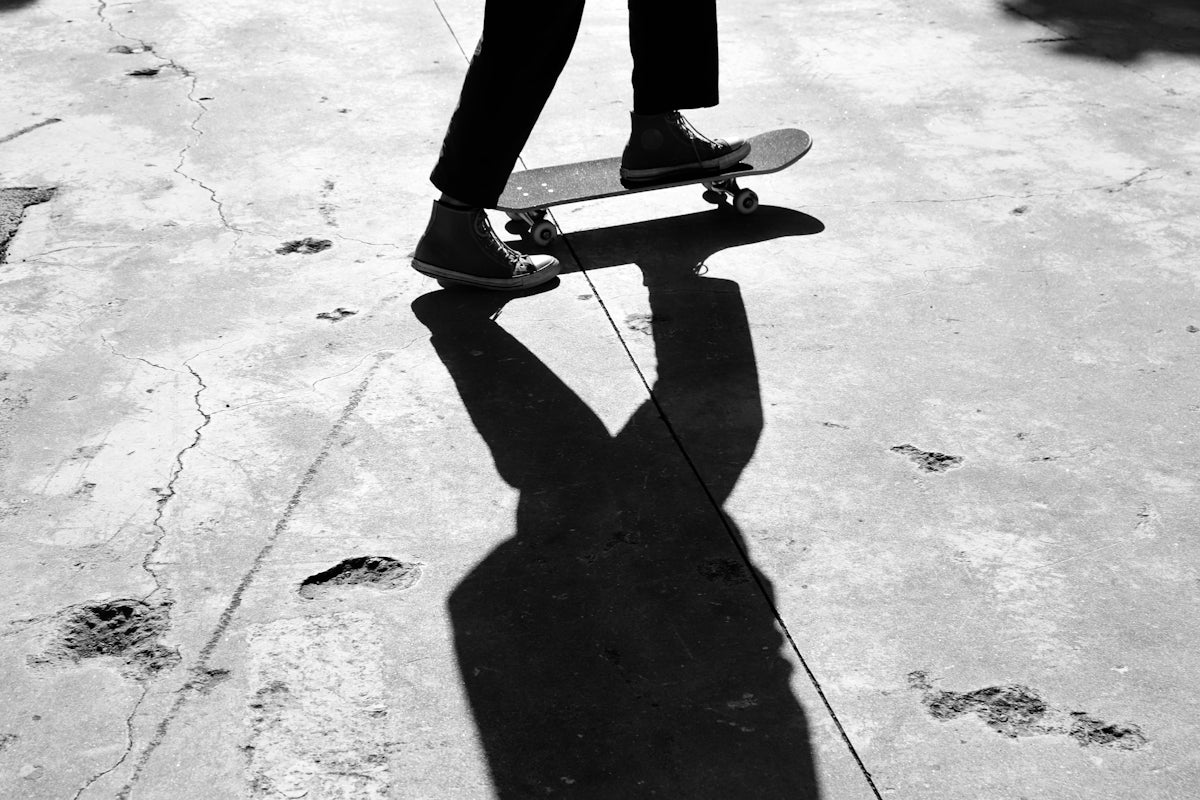 person in black pants and black shoes standing on gray concrete floor