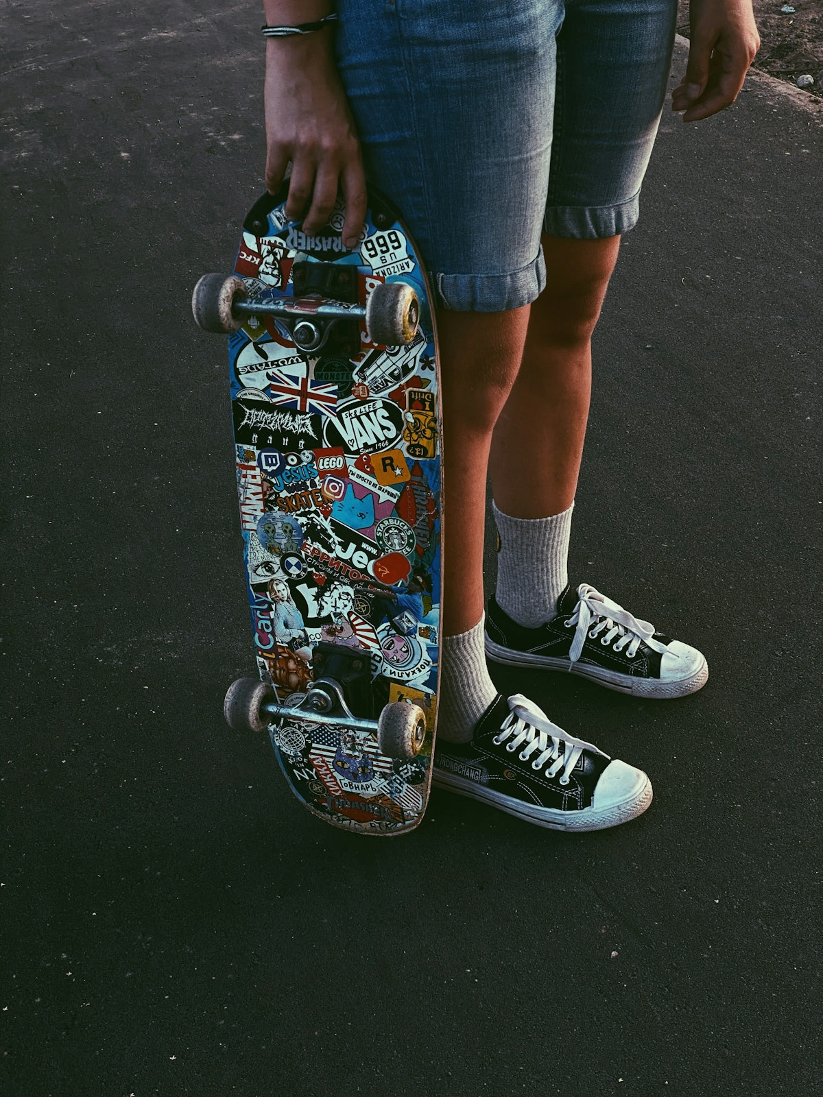 person in blue denim shorts and black and white nike sneakers riding skateboard