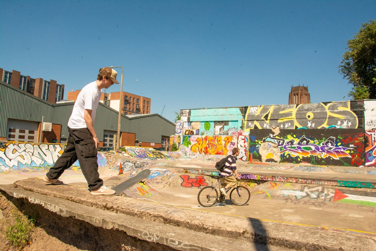 Two young men skateboarding and biking outdoors