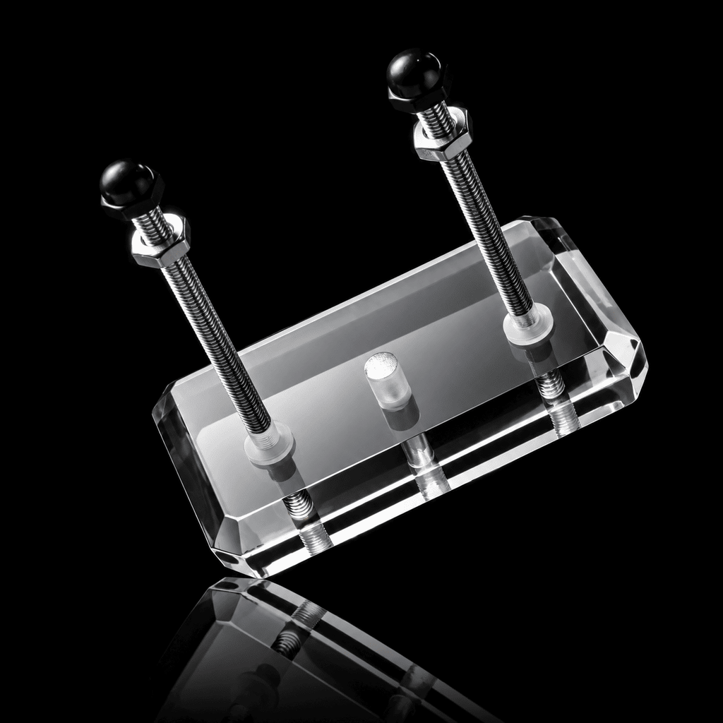 Clear acrylic skateboard wall mount block with two upright steel rods and black cap nuts on a black background